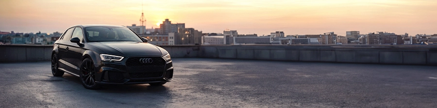 Audi A3 auf dem Dach eines Parkhauses bei Sonnenuntergang