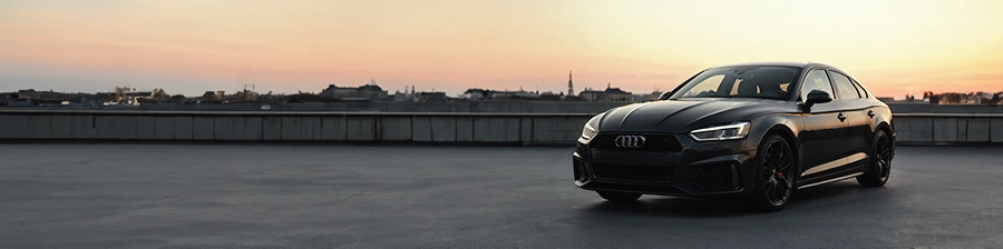 Audi A5 auf dem Dach eines Parkhauses bei Sonnenuntergang